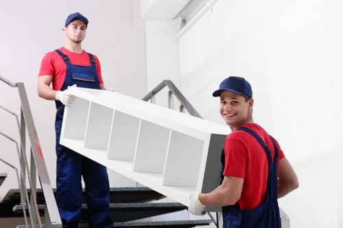 Removalists carrying furniture through a residential street in Streatham